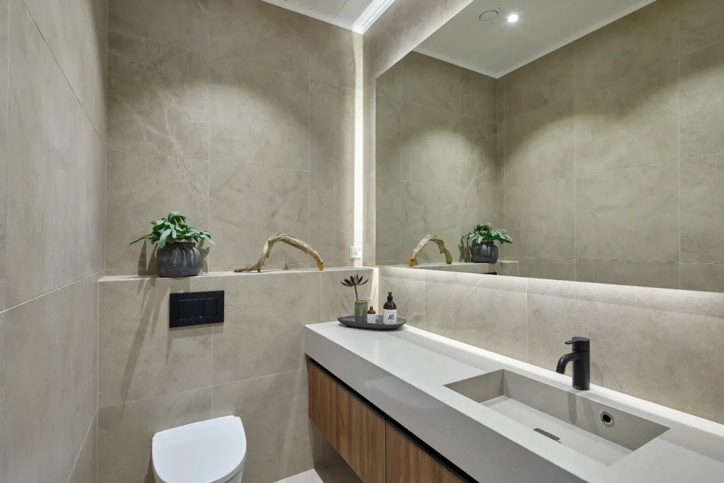 Moderni wc-tila kivipinnoilla ja puuyksityiskohdilla – sisustussuunnittelu Naantali