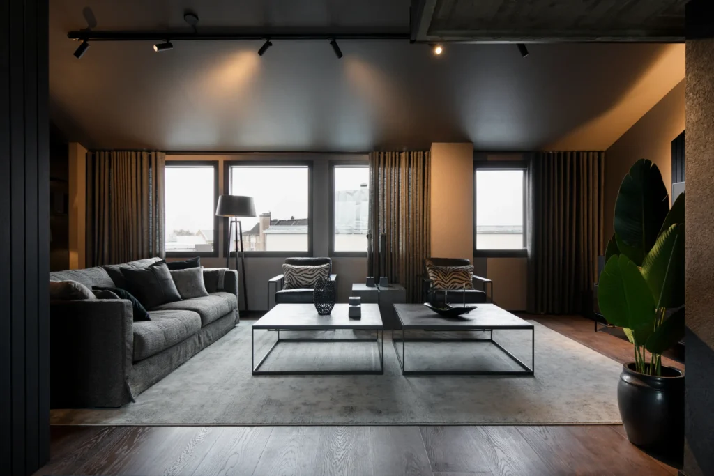 Valoisa olohuone suurilla ikkunoilla, moderni kalustus ja pehmeät tekstiilit – sisustussuunnittelu Helsingissä