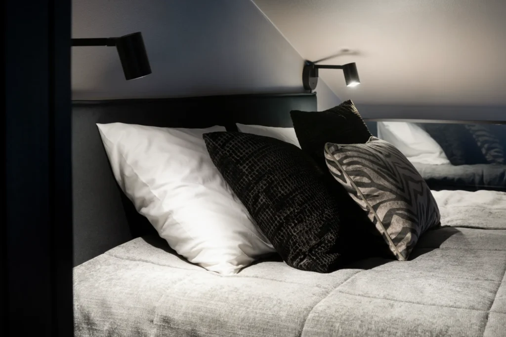 Lähikuva makuuhuoneen tekstiileistä ja tyynyistä, pehmeä ja harmoninen sisustussuunnittelu Helsingissä