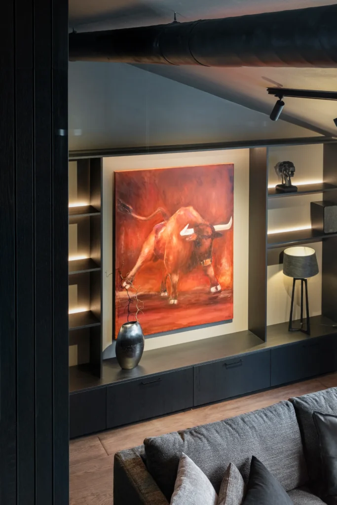 Olohuoneen taideseinä ja valaistut hyllyt, näyttävä kokonaisuus – sisustussuunnittelu Helsingissä