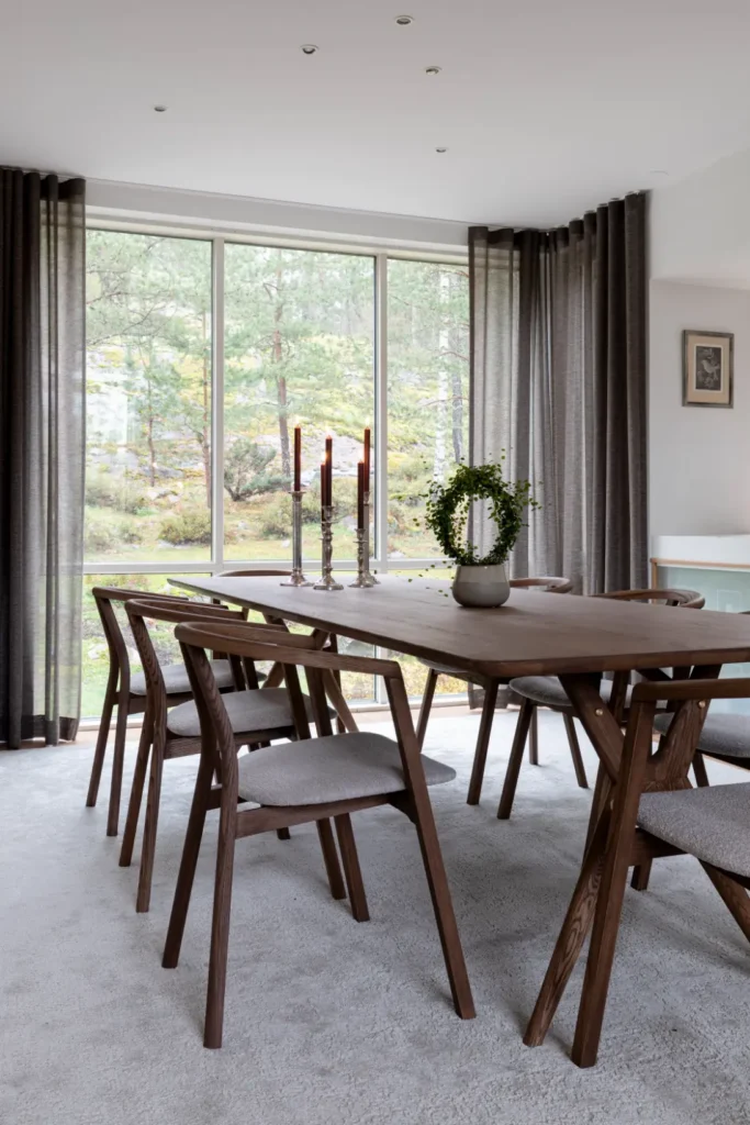 Tunnelmallinen ruokailutila ja näyttävä riippuvalaisin luovat lämpimän kokonaisuuden – sisustussuunnittelu Espoo Nuuksio