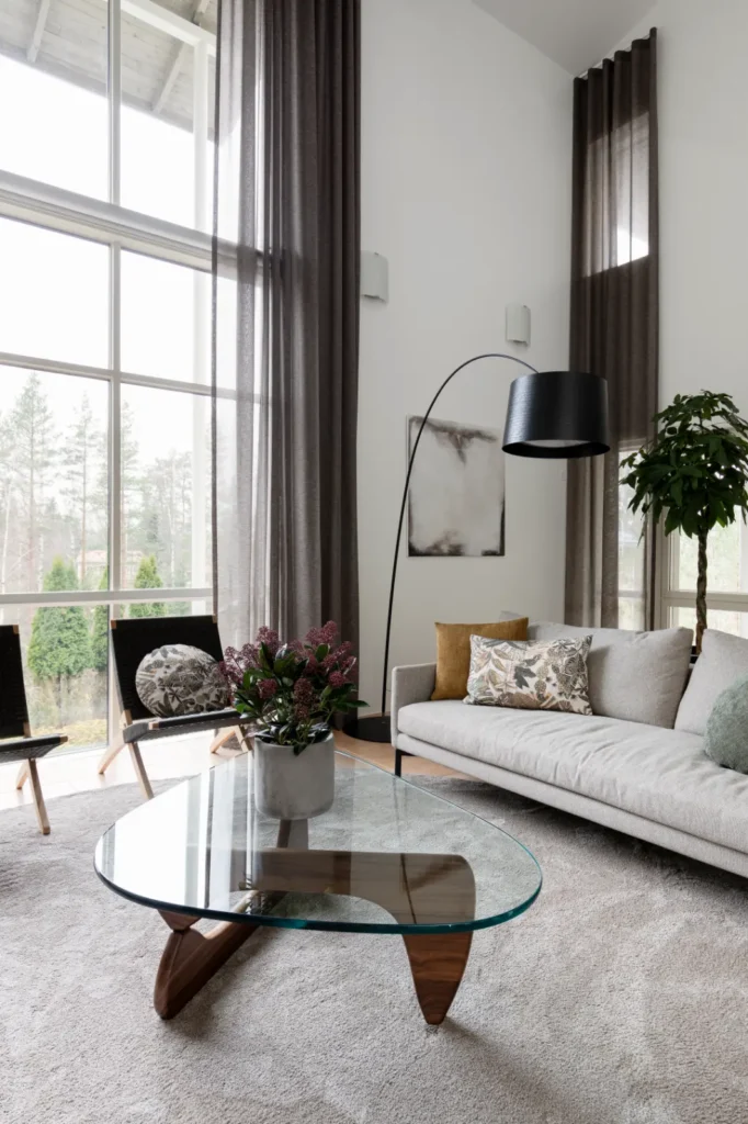 Moderni olohuone lasipöydällä ja harmonisilla sävyillä – sisustussuunnittelu Espoo Nuuksio
