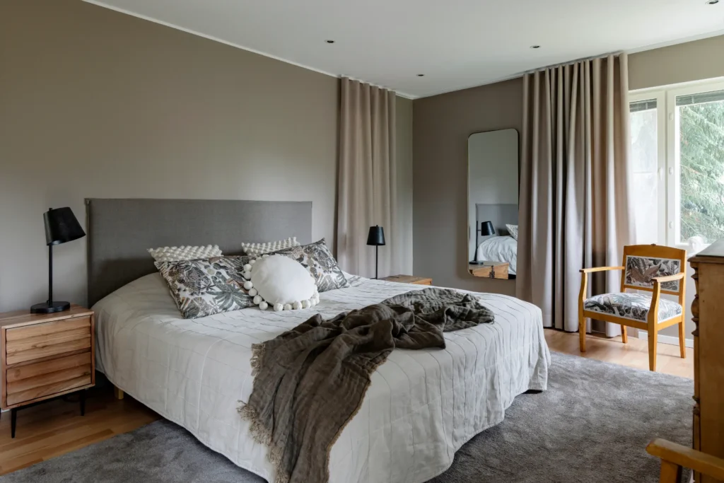 Rauhallinen makuuhuone pehmeillä tekstiileillä ja neutraaleilla sävyillä – sisustussuunnittelu Espoo Nuuksio