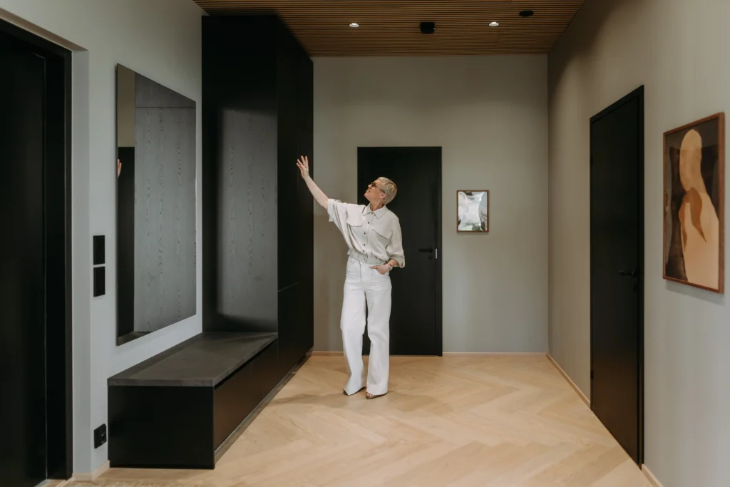 sisustussuunnittelija tutkii korkeaa kaapistoa – sisustussuunnittelu Espoo Saunalahti