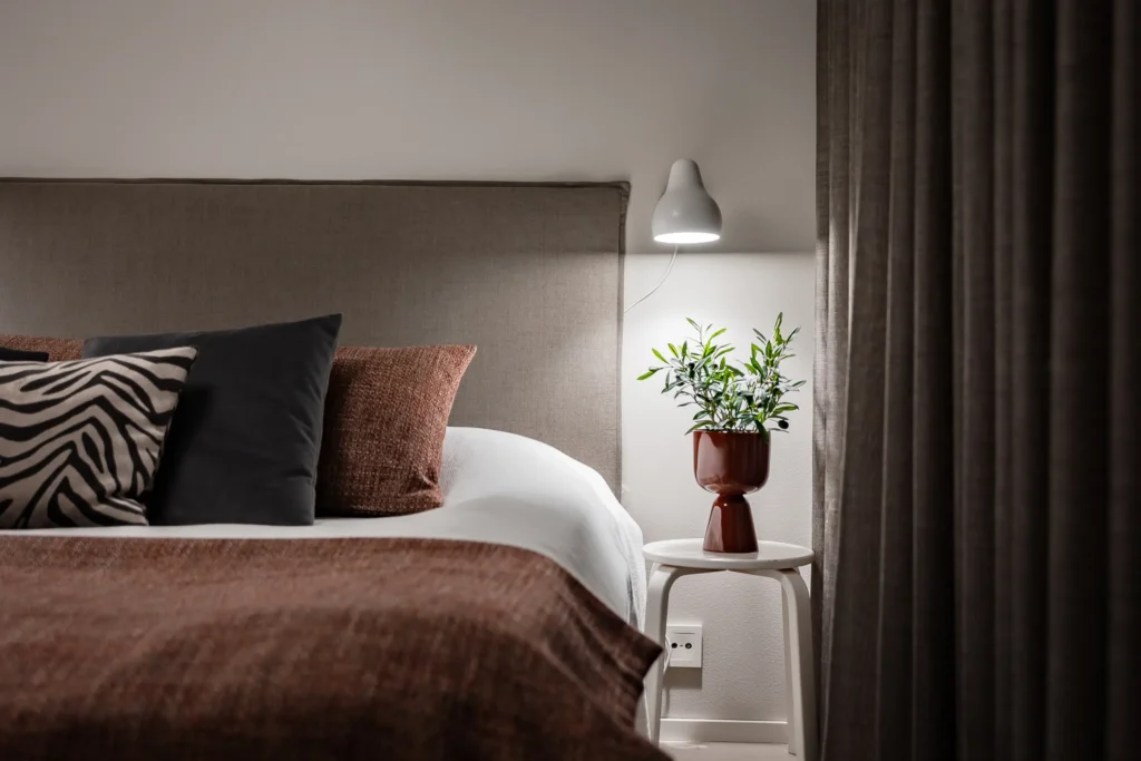 Makuuhuoneen yksityiskohta yöpöydällä ja kasvilla – sisustussuunnittelu Espoo Soukka