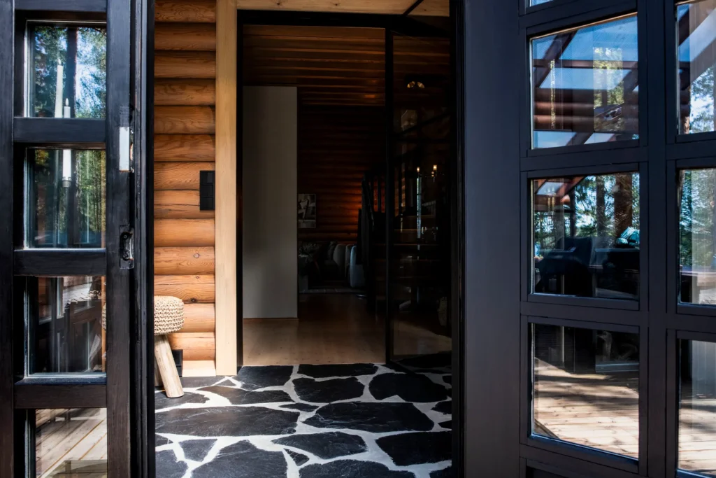 Sisääntulo modernilla kivilaattalattialla ja tummilla yksityiskohdilla – sisustussuunnittelu Sysmä