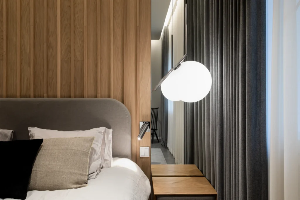 Moderni sängynpääty ja puupaneeliseinä valaistuksella – sisustussuunnittelu Nurmijärvi